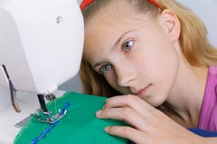 Um adolescente está interessado em processo da costura na máquina de costura imagem de stock Um adolescente está interessado em processo da costura na máquina de costura imagem de stock