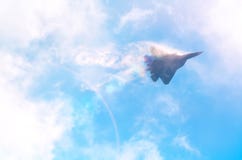 Um avião de lutador militar na alta velocidade, nuvens altas de voo no céu, brilho da luz do sol foto de stock Um avião de lutador militar na alta velocidade, nuvens altas de voo no céu, brilho da luz do sol foto de stock