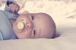 Um bebê recém-nascido pequeno suga uma chupeta A criança é feita crochê Tonificação, borrão foto de stock Um bebê recém-nascido pequeno suga uma chupeta A criança é feita crochê Tonificação, borrão foto de stock