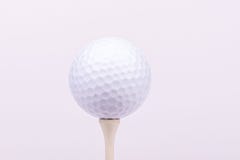 Um brilhante, retrato da alto-chave de uma bola de golfe em um T imagens de stock royalty free Um brilhante, retrato da alto-chave de uma bola de golfe em um T imagens de stock royalty free