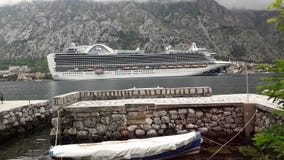 Um cruzador grande na baía de Kotor em um canal banhado à vista do sol imagem de stock Um cruzador grande na baía de Kotor em um canal banhado à vista do sol imagem de stock