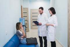 Um doutor e uma enfermeira que discutem o diagnóstico com o paciente ou o parente no assoalho do hospital foto de stock Um doutor e uma enfermeira que discutem o diagnóstico com o paciente ou o parente no assoalho do hospital foto de stock