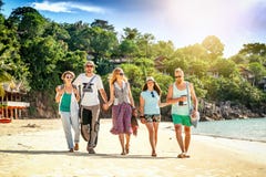 Um grupo de amigos dos jovens 30 anos anda na praia, happ imagens de stock Um grupo de amigos dos jovens 30 anos anda na praia, happ imagens de stock