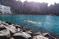 Um grupo de pessoas em caiaque está navegando Itália, Sorrento, baía do meta é destino popular do turista para o esporte que kaya fotografia de stock Um grupo de pessoas em caiaque está navegando Itália, Sorrento, baía do meta é destino popular do turista para o esporte que kaya fotografia de stock