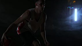 Um homem adulto novo, bola do fluxo do jogador de basquetebol, da obscuridade campo de básquete dentro Fumo vídeos de arquivo Um homem adulto novo, bola do fluxo do jogador de basquetebol, da obscuridade campo de básquete dentro Fumo vídeos de arquivo