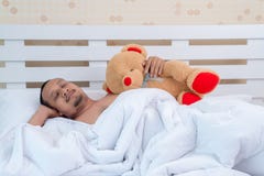 Um homem bonito dorme inocentemente na cama antes do trabalho foto de stock Um homem bonito dorme inocentemente na cama antes do trabalho foto de stock