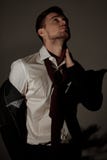 Um homem de negócios cansado está em uma camisa com descolagem do revestimento e foto de stock Um homem de negócios cansado está em uma camisa com descolagem do revestimento e foto de stock