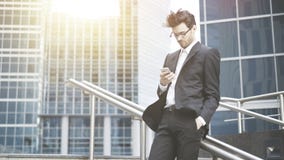 Um homem de negócios novo está enrolando o telefone imagens de stock Um homem de negócios novo está enrolando o telefone imagens de stock