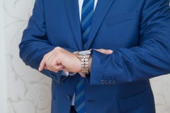 Um homem em um terno está olhando seu relógio imagem de stock Um homem em um terno está olhando seu relógio imagem de stock