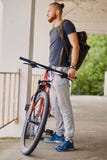 Um homem senta-se em uma bicicleta vermelha da montanha exterior imagens de stock Um homem senta-se em uma bicicleta vermelha da montanha exterior imagens de stock