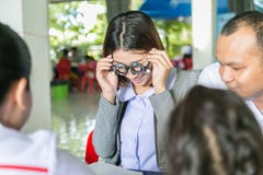 Um jovem asiático nutre fazer testes da visão usando a experimentação ótica franco imagens de stock Um jovem asiático nutre fazer testes da visão usando a experimentação ótica franco imagens de stock
