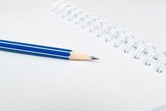 Um lápis do bleu e um caderno branco imagens de stock Um lápis do bleu e um caderno branco imagens de stock