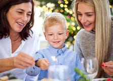Um menino pequeno com a mãe e a avó que guardam a faísca no tempo do Natal fotos de stock royalty free Um menino pequeno com a mãe e a avó que guardam a faísca no tempo do Natal fotos de stock royalty free