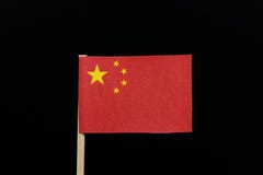 Um original e simplesmente uma bandeira de China no palito no fundo preto Uma grande estrela dourada dentro de um arco de quatro foto de stock Um original e simplesmente uma bandeira de China no palito no fundo preto Uma grande estrela dourada dentro de um arco de quatro foto de stock