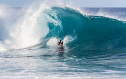 Um surfista da placa do corpo que monta uma onda fotos de stock Um surfista da placa do corpo que monta uma onda fotos de stock