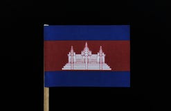 Uma bandeira original e original de Camboja no palito no fundo preto Três faixas horizontais de azul, de vermelho e de azul, com fotografia de stock royalty free Uma bandeira original e original de Camboja no palito no fundo preto Três faixas horizontais de azul, de vermelho e de azul, com fotografia de stock royalty free