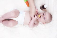 Uma criança muito pequena, um bebê, encontra-se para trás no escritório do doutor e o doutor escuta os pulmões foto de stock royalty free Uma criança muito pequena, um bebê, encontra-se para trás no escritório do doutor e o doutor escuta os pulmões foto de stock royalty free
