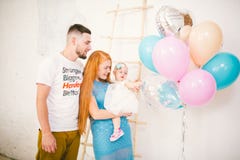 Uma família nova de três povos, de paizinho do ` s da mamã e de bebê de um ano do ` s da filha está dentro da sala Guardando um b imagens de stock royalty free Uma família nova de três povos, de paizinho do ` s da mamã e de bebê de um ano do ` s da filha está dentro da sala Guardando um b imagens de stock royalty free