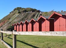 Uma fileira de cabanas da praia na praia da telha em Branscome em Devon, Inglaterra fotos de stock Uma fileira de cabanas da praia na praia da telha em Branscome em Devon, Inglaterra fotos de stock