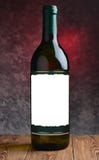 Uma garrafa do vinho seco branco em uma tabela de madeira no fundo de um muro de cimento Copie a etiqueta vazia branca do espaço fotos de stock royalty free Uma garrafa do vinho seco branco em uma tabela de madeira no fundo de um muro de cimento Copie a etiqueta vazia branca do espaço fotos de stock royalty free
