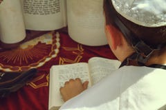 Uma ideia traseira de rezar a mão do homem novo com um tefillin que guarda um livro da Bíblia, ao ler rezar em um ritual judaico imagem de stock royalty free Uma ideia traseira de rezar a mão do homem novo com um tefillin que guarda um livro da Bíblia, ao ler rezar em um ritual judaico imagem de stock royalty free