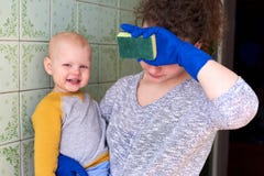 Uma m?e com seu filho pequeno est? limpando a casa O conceito de combinar trabalhos de casa e de aumentar uma crian?a fotografia de stock Uma m?e com seu filho pequeno est? limpando a casa O conceito de combinar trabalhos de casa e de aumentar uma crian?a fotografia de stock