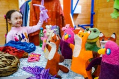 Uma menina asiática da idade escolar joga com um teatro do fantoche da boneca imagem de stock Uma menina asiática da idade escolar joga com um teatro do fantoche da boneca imagem de stock