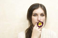 Uma menina que guarda a flor do primerose que finge o fumo imagens de stock Uma menina que guarda a flor do primerose que finge o fumo imagens de stock