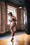 Uma mulher do atleta que corre na hora no gym brilhante foto de stock Uma mulher do atleta que corre na hora no gym brilhante foto de stock