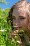 Uma mulher está cheirando em flores no parque imagens de stock royalty free Uma mulher está cheirando em flores no parque imagens de stock royalty free