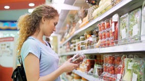 Uma pessoa fêmea escolhe produtos no mercado grande Uma pessoa fêmea escolhe produtos no mercado grande
