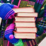 Uma pilha de livros nas mãos de um homem na roupa brilhante Um homem distribui livros na rua Promoção do livro Seis livros com a imagens de stock royalty free Uma pilha de livros nas mãos de um homem na roupa brilhante Um homem distribui livros na rua Promoção do livro Seis livros com a imagens de stock royalty free