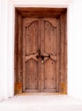 Uma porta de madeira velha, parede branca imagens de stock Uma porta de madeira velha, parede branca imagens de stock