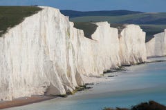 Uma vista bonita dos sete penhascos de giz das irmãs no abrigo de Cuckmere na costa sul de Inglaterra imagem de stock Uma vista bonita dos sete penhascos de giz das irmãs no abrigo de Cuckmere na costa sul de Inglaterra imagem de stock