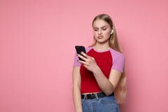 Umgekipptes junges M?dchen mit dem blonden Haar und den Kopfh?rern unter Verwendung des Telefons lizenzfreie stockfotos Umgekipptes junges M?dchen mit dem blonden Haar und den Kopfh?rern unter Verwendung des Telefons lizenzfreie stockfotos