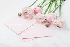 Umschlag oder Buchstabe, Papierkarte und rosa Ranunculus blüht auf weißer Tabelle für den Gruß am Mutter-oder Frauen-Tag stockbild Umschlag oder Buchstabe, Papierkarte und rosa Ranunculus blüht auf weißer Tabelle für den Gruß am Mutter-oder Frauen-Tag stockbild