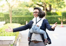 Un abbraccio del figlio il suoi padre e sorriso con il vestito casuale nel parco fotografie stock libere da diritti Un abbraccio del figlio il suoi padre e sorriso con il vestito casuale nel parco fotografie stock libere da diritti