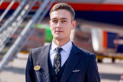 Un amministratore bello e coraggioso vestito in uniforme blu scuro ufficiale delle linee aeree di Aeroflot sull'aerodromo immagine stock Un amministratore bello e coraggioso vestito in uniforme blu scuro ufficiale delle linee aeree di Aeroflot sull'aerodromo immagine stock