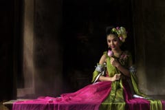 Un ange asiatique de conte de fées a orné avec des fleurs de lotus se reposant sur a images stock Un ange asiatique de conte de fées a orné avec des fleurs de lotus se reposant sur a images stock