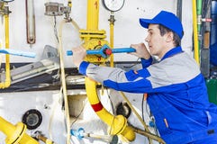 Un'attrezzatura con esperienza della caldaia a gas di servizio di operatore immagine stock libera da diritti Un'attrezzatura con esperienza della caldaia a gas di servizio di operatore immagine stock libera da diritti