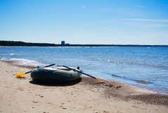 Un barco inflable en la mañana temprana de la primavera en la costa del mar Báltico Fotos de archivo libres de regalías Un barco inflable en la mañana temprana de la primavera en la costa del mar Báltico Fotos de archivo libres de regalías