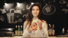 Un barista femenino joven hermoso que prueba un mojito de la fresa almacen de metraje de vídeo Un barista femenino joven hermoso que prueba un mojito de la fresa almacen de metraje de vídeo