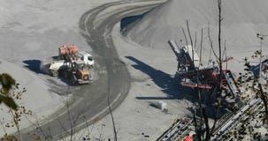 Un bouteur dans une carri?re charge une pierre dans le corps d'un camion ? benne basculante, un budozer jaune travaille dans une banque de vidéos Un bouteur dans une carri?re charge une pierre dans le corps d'un camion ? benne basculante, un budozer jaune travaille dans une banque de vidéos