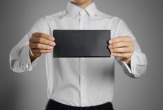 Un cameriere nella camicia bianca che tiene il chiaro nero in bianco del lei fotografie stock Un cameriere nella camicia bianca che tiene il chiaro nero in bianco del lei fotografie stock