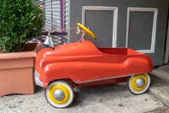 Un camion dei vigili del fuoco rosso & giallo luminoso del giocattolo sta fuori l'ambiente concreto grigio triste di againsta fotografia stock libera da diritti Un camion dei vigili del fuoco rosso & giallo luminoso del giocattolo sta fuori l'ambiente concreto grigio triste di againsta fotografia stock libera da diritti
