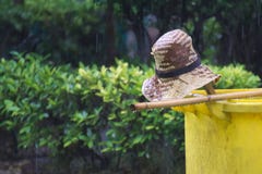 Un cappello di paglia, una scopa tailandese semplice e un bidone della spazzatura giallo; tutti abbandonati rapidamente a causa d fotografia stock Un cappello di paglia, una scopa tailandese semplice e un bidone della spazzatura giallo; tutti abbandonati rapidamente a causa d fotografia stock