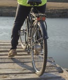 Un ciclista guida un ponte di legno su una bicicletta immagini stock Un ciclista guida un ponte di legno su una bicicletta immagini stock