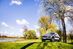 Un coche en la hierba verde cerca del lago fotos de archivo libres de regalías Un coche en la hierba verde cerca del lago fotos de archivo libres de regalías