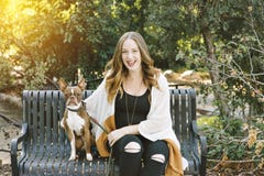 Un dueño del perro se sienta con su perro en una sonrisa feliz del banco de parque imágenes de archivo libres de regalías Un dueño del perro se sienta con su perro en una sonrisa feliz del banco de parque imágenes de archivo libres de regalías