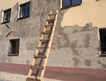 Un edificio viejo con la fachada dañada con la escalera de madera por la pared imagenes de archivo Un edificio viejo con la fachada dañada con la escalera de madera por la pared imagenes de archivo